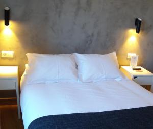 毕尔巴鄂唐克劳迪奥膳食公寓的一张带白色床单和枕头的床