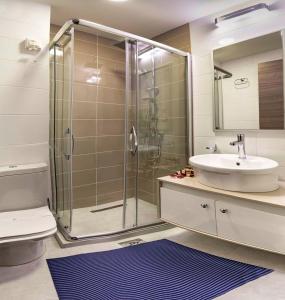 VinicaCentral Hotel, Fitness and Spa的一间带玻璃淋浴和水槽的浴室