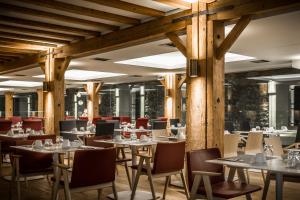 兹拉马海德拉玛大酒店的餐厅设有木柱子和桌椅