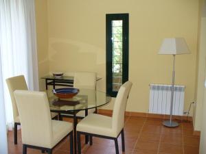 纳瓦拉Villa Torremirona Resort Palmeras的一间设有玻璃桌和白色椅子的用餐室