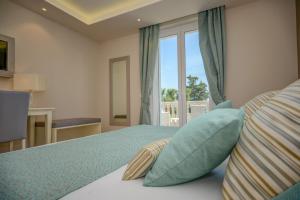 加达湖畔帕登赫Hotel Villa Garuti的一间卧室配有一张带蓝色枕头的床和一扇窗户。