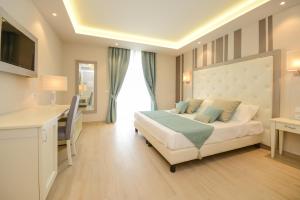 加达湖畔帕登赫Hotel Villa Garuti的配有一张床、一张书桌和一扇窗户的酒店客房