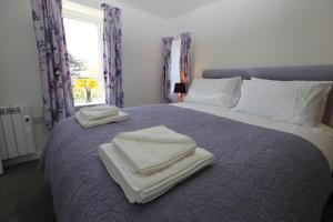 斯托诺韦Chapman's的床上的床铺,上面有毛巾,还有窗户