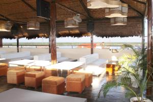 普卡尔帕Rio Boutique Hotel的一间设有白色家具并享有海景的餐厅