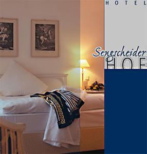 圣英贝特Hotel Restaurant Sengscheider Hof的一间卧室配有一张床和一张带台灯的桌子