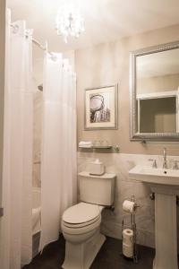 纽约西部三号俱乐部酒店的一间带卫生间、水槽和镜子的浴室
