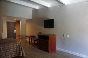 克莱蒙罗德威酒店的酒店客房,设有床铺和墙上的电视