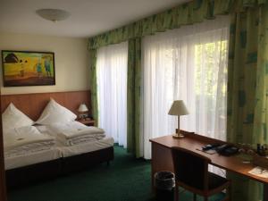 汉诺威Frick's Hotel的卧室配有一张床、一张书桌和窗户。