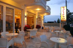 帕拉利亚卡泰里尼斯Kalipso的庭院内的餐厅,配有桌椅