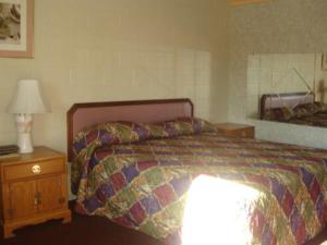 图莱里乡村客栈的一间卧室,配有一张床和床头灯