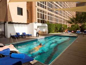 迪拜阿拉伯庭院水疗酒店的建筑物游泳池里的人