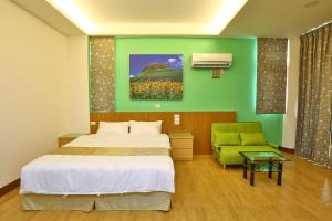 马公长成民宿的一间卧室设有一张床和绿色的墙壁