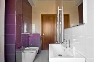 阿谢亚inStile aparthotel的浴室配有水槽、卫生间和紫色瓷砖