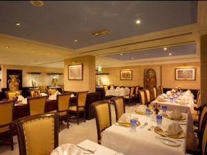 迪拜阿拉伯庭院水疗酒店的一间设有白色桌椅的餐厅