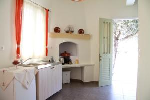 阿提蒙Aggelis Villa的白色的厨房设有水槽和窗户