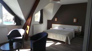 Cléden-Cap-Sizun罗莱普安特杜凡酒店的一间卧室配有一张床、一把椅子和一张桌子
