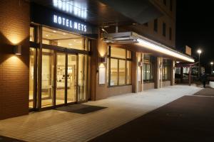 北上市JR-East Hotel Mets Kitakami的夜间在建筑物前的商店