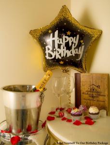 普雷斯顿普雷斯顿10号公寓式酒店的一张桌子上装着纸杯蛋糕的生日快乐标志
