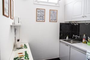 蓬塔德尔加达Cosy Flat in City Center的白色的厨房设有水槽和台面