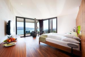 吕施利孔贝尔沃瑞士优质酒店的一间卧室设有一张大床和大窗户