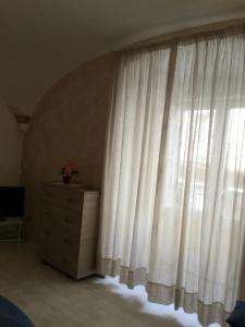 索伦托我的套房索伦托酒店的卧室设有窗户、白色窗帘和梳妆台
