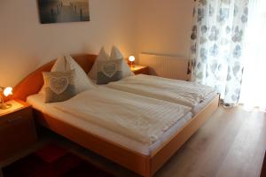 沃尔特湖畔韦尔登Kusternighof的一间卧室配有带白色床单和枕头的床。