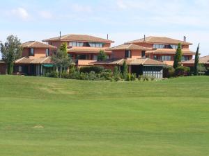 纳瓦拉Villa Torremirona Resort Palmeras的山丘上一群房子,有一座绿色的院子