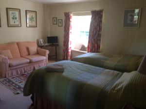 米尔顿凯恩斯Mill Farm的一间卧室配有一张床、一张沙发和一个窗口