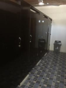 努库阿洛法The Village Backpackers的浴室设有黑色门,铺有瓷砖地板。