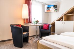 库罗阿尔滕堡Pension Hotel Sartor的酒店客房带一张床、一张桌子和椅子
