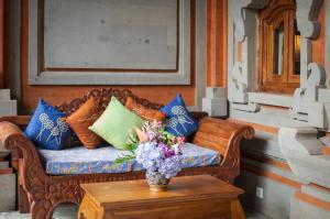 乌布塔曼拉哈希亚热带保护区和Spa的一张带枕头的沙发,一张桌子上放着花瓶