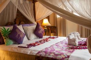 乌布塔曼拉哈希亚热带保护区和Spa的一间卧室,床上放着鲜花