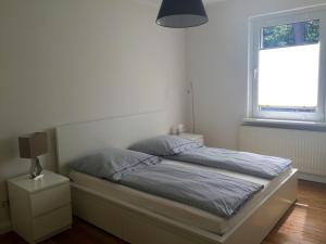 博尔滕哈根Haus Sonnenschein的白色卧室内的一张床位,卧室设有窗户