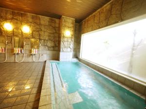 裾野市如特酒店 - 苏斯诺因特尔酒店的石头墙房的游泳池