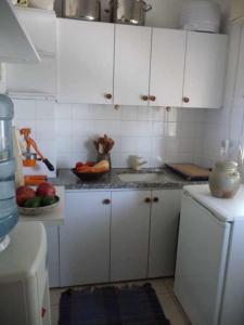 海法哈法湾艺术之家公寓的厨房配有白色橱柜和一碗水果