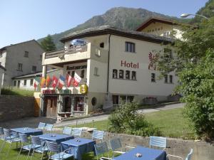 Simplon DorfHotel-Restaurant Grina的酒店前面设有桌椅