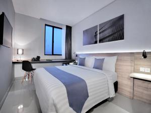 Hotel Neo Gajah Mada Pontianak by ASTON客房内的一张或多张床位