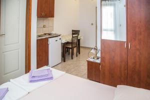 佩特罗瓦纳莫鲁Apartmani Ksenija的客房设有厨房和带床的桌子。