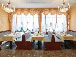 慕尼黑赞图姆阿尔法酒店的用餐室设有2张桌子和椅子以及大窗户