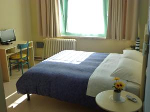 葛伦坦马勒Villa Paola的配有一张床、一张桌子和一张桌子的酒店客房
