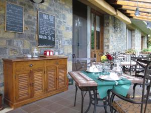 圣胡安德普兰卡萨安妮塔酒店的庭院中设有1间带桌椅的餐厅