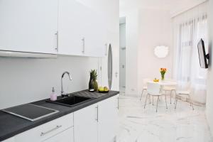 克拉科夫市中心泽博凯维扎典雅公寓14的白色的厨房配有水槽和桌子
