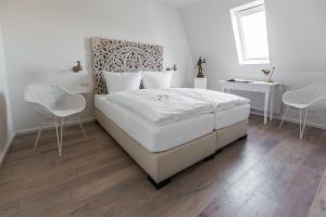 奥尔登堡Villa Stern的卧室配有一张白色大床和两把椅子