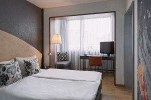 伯尔尼拉裴格拉伯尔尼酒店的一间卧室配有一张床、一张书桌和一台电视