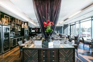 威布里治力推布鲁克兰酒店&SPA的一间带桌椅和花瓶的餐厅