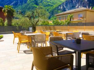 加尔达湖滨GardaBreak Rooms&Breakfast Holiday Apartments的庭院配有桌椅,背景为山脉