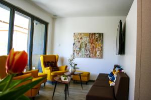 加尔达湖滨GardaBreak Rooms&Breakfast Holiday Apartments的客厅配有黄色椅子和沙发