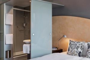 伯尔尼拉裴格拉伯尔尼酒店的一间卧室配有一张床,浴室设有淋浴。
