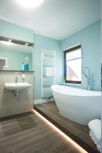 策尔廷根-拉蒂希圣斯特普诺斯维纳酒店的浴室配有白色浴缸和水槽