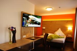 格尔斯托芬格斯索夫奥泽特酒店的一间设有床铺和墙上电视的客房